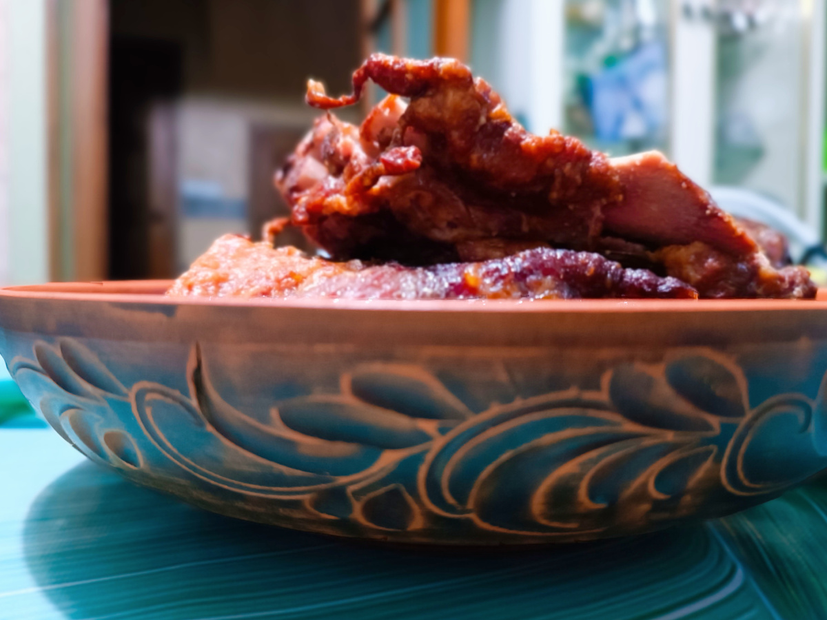 Обновка в доме - глиняная миска с узорами. А в миске разваренные копченые ребрышки. 