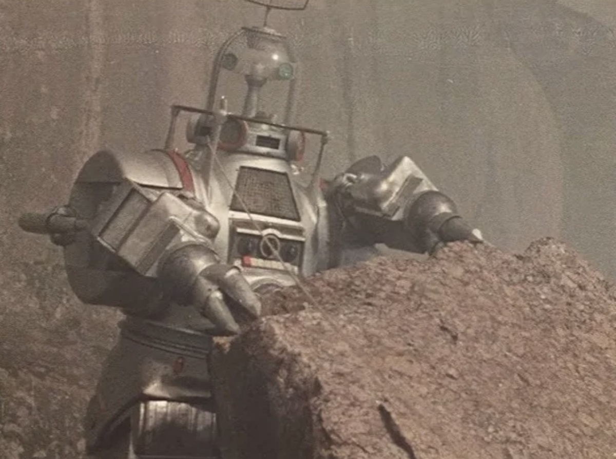 «Планета бурь» (1961)
Джон — искусственный помощник советско-американской команды космонавтов, который прилетает на полную динозавров и прочих опасностей Планету бурь. Сначала этот робот-трансформер со стеклянным куполом вместо головы чуть не губит, но потом спасает космонавтов от потоков кипящей лавы, жертвуя собой.