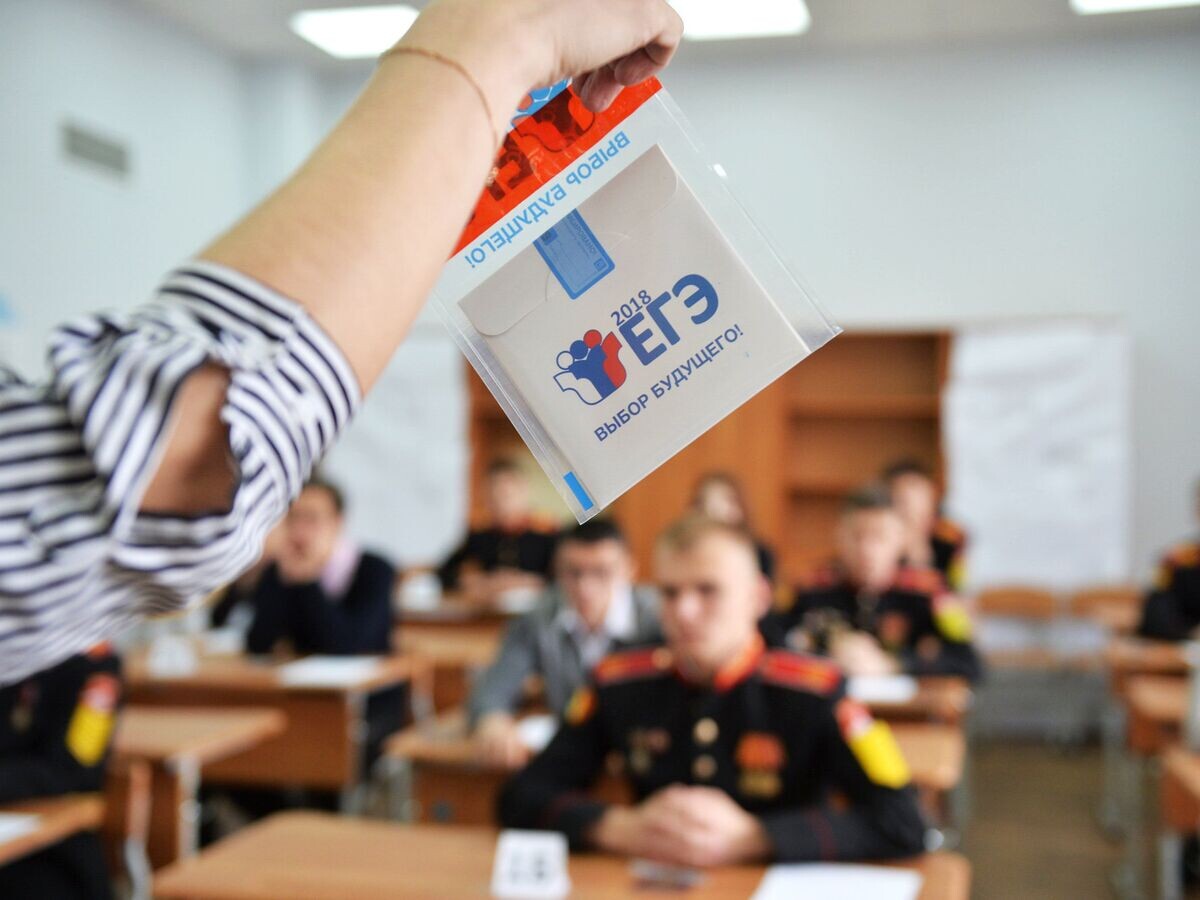    Преподаватель демонстрирует пакет и компакт-диск с заданиями перед началом ЕГЭ по математике в Екатеринбурге© РИА Новости / Павел Лисицын