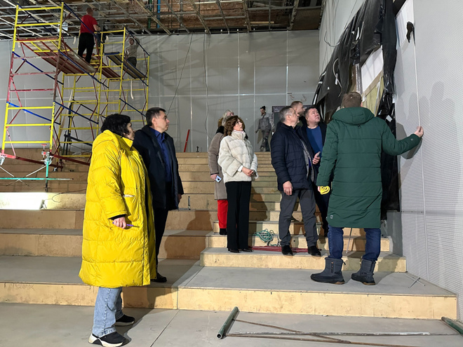 
Представители администрации осматривают недавно установленные стеновые панели в зрительном зале