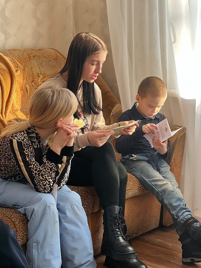 Дети изучают буклеты с информацией о Детском телефоне доверия