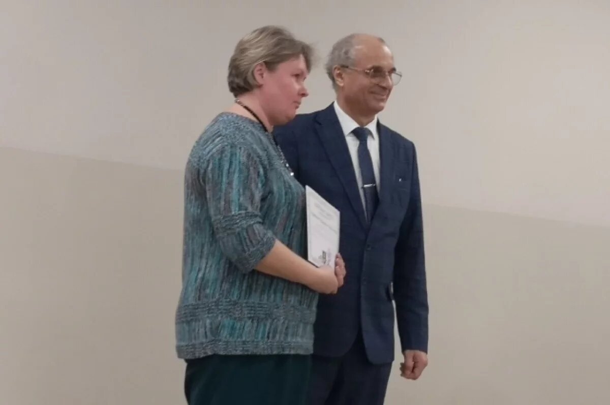    Врио ректора Тверского государственного университета Сергей Смирнов вручает благодарственное письмо кандидату биологических наук Екатерине Прутенской.