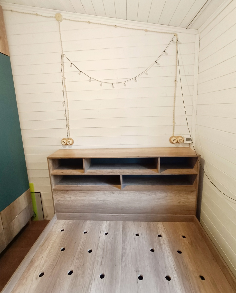 на фото видно расстояние между кроватью и шкафом. Плинтус находится справа от кровати.  Над изголовьем - квадратный терморегулятор