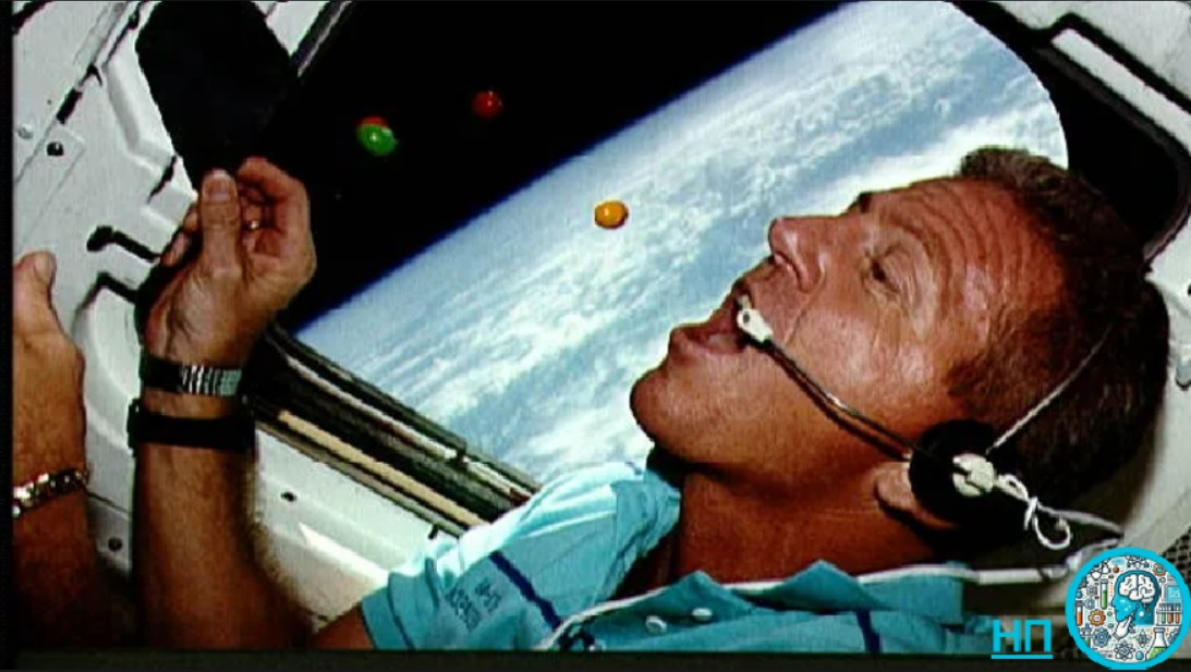 Астронавт Лорен Дж. Шрайвер гоняется за плавающими шоколадными конфетами M&M's с арахисом в кормовой части шаттла «Атлантис»