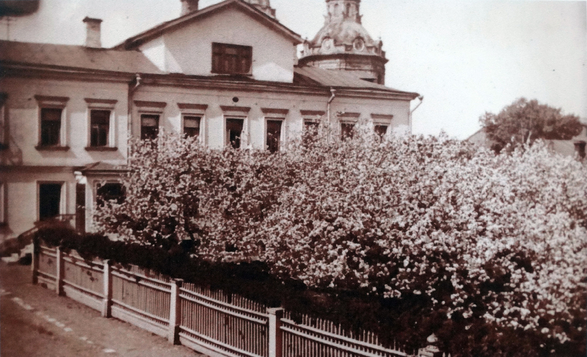 Уютный московский домик XIX века с садом. Цветущие деревья, аккуратный заборчик и на заднем плане уже знакомый нам храм Параскевы Пятницы. С этого ракурса храм навевает мне воспоминания о римской архитектуре, но это Москва, которую мы потеряли