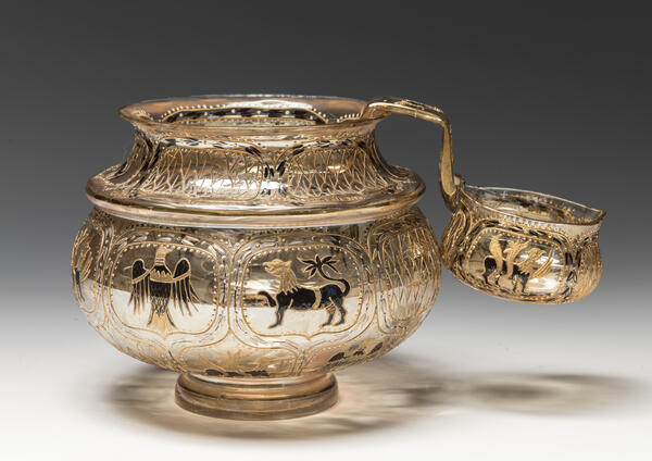 Дятьковский хрустальный завод Братина и ковш По эскизу Е. М. Бём (1843--1914). 1893-1900 Стекло, выдувание, иризация, роспись эмалевыми красками и золотом. 16,8;х21,4 см (братина); 9,5 х 16,7 (ковш) ГРМ