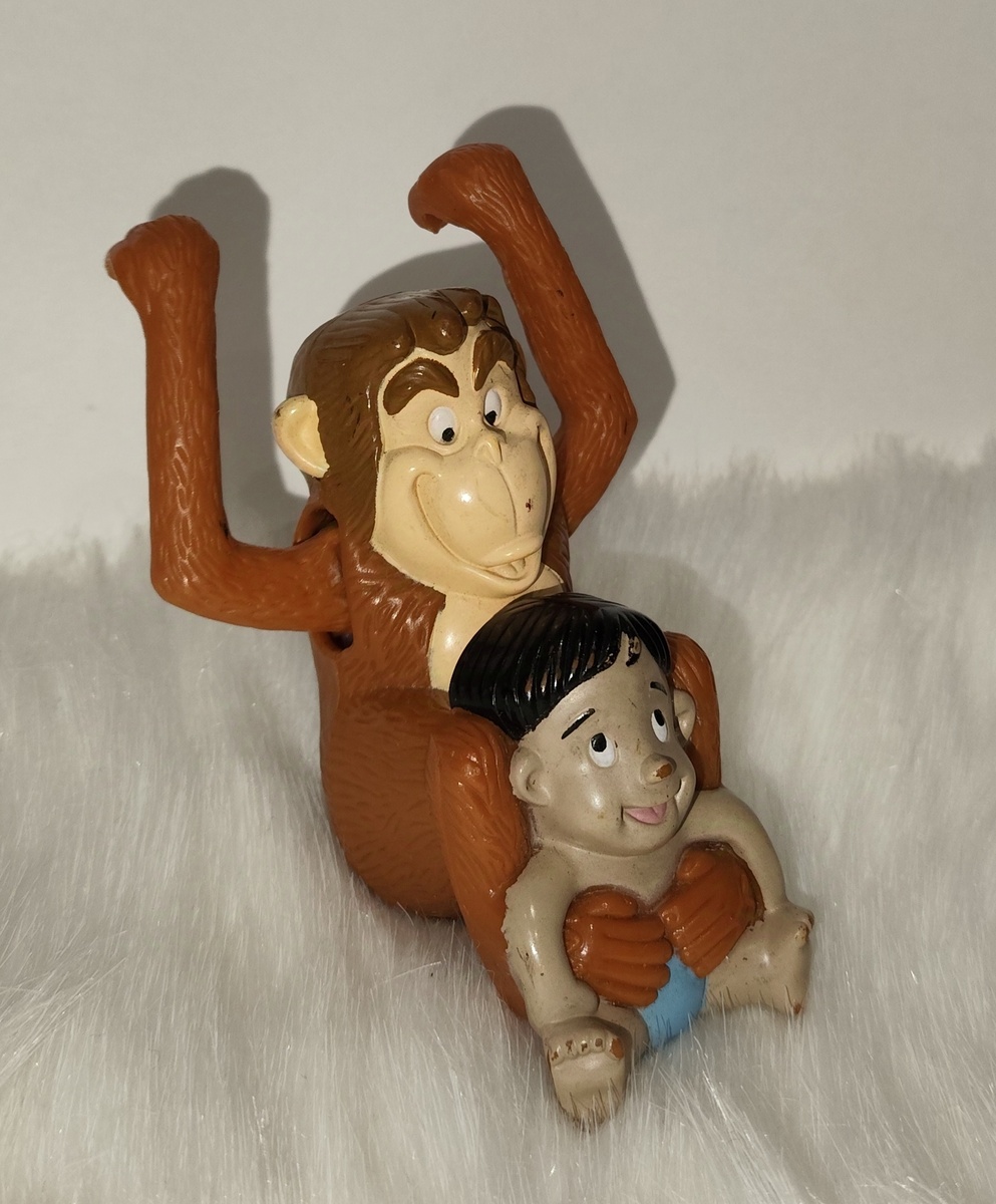 Обезьяна бандерлог с маленьким Маугли 