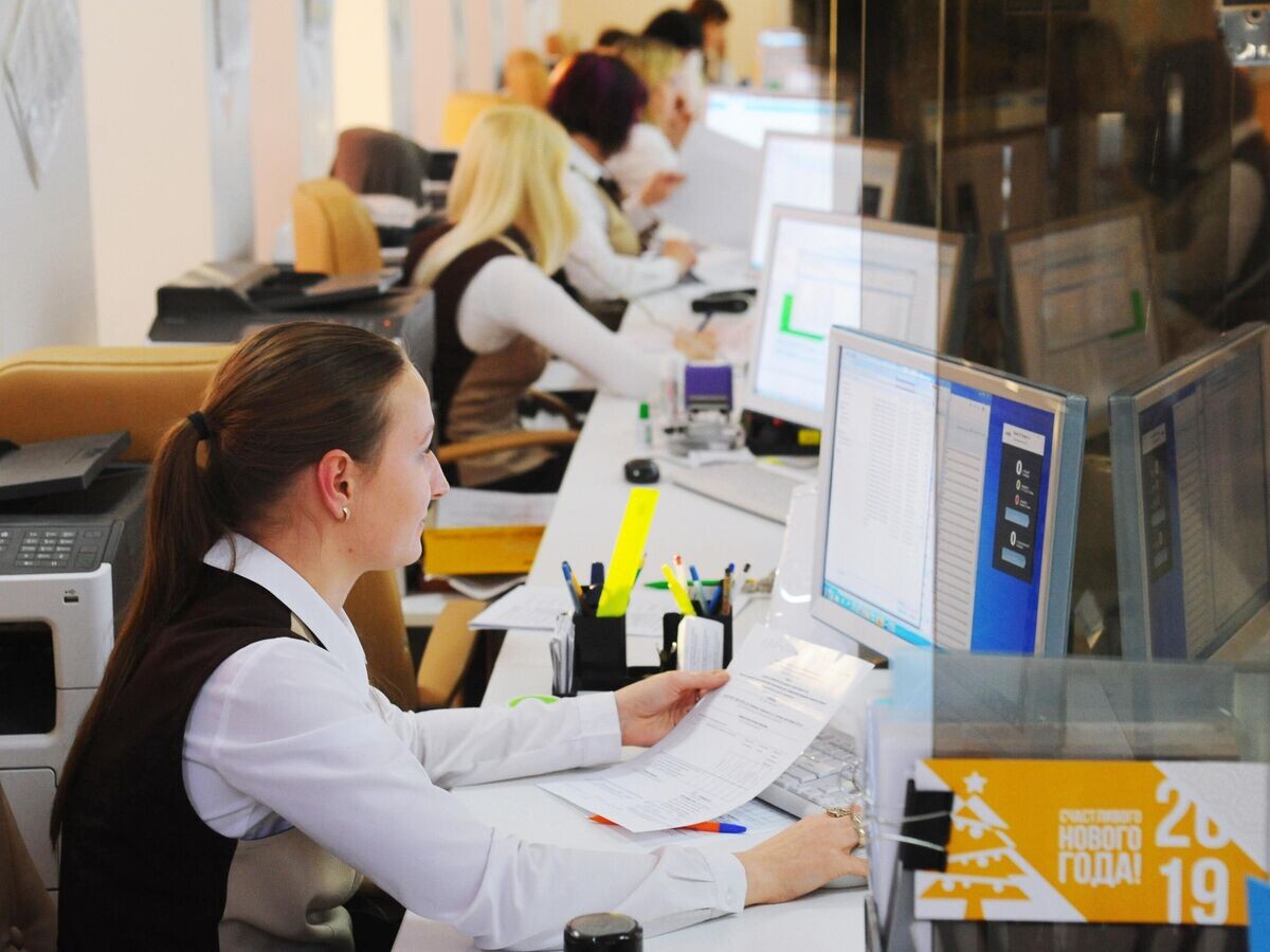    Специалисты Тамбовского филиала МФЦ за работой в зоне обслуживания© РИА Новости / Алексей Сухоруков