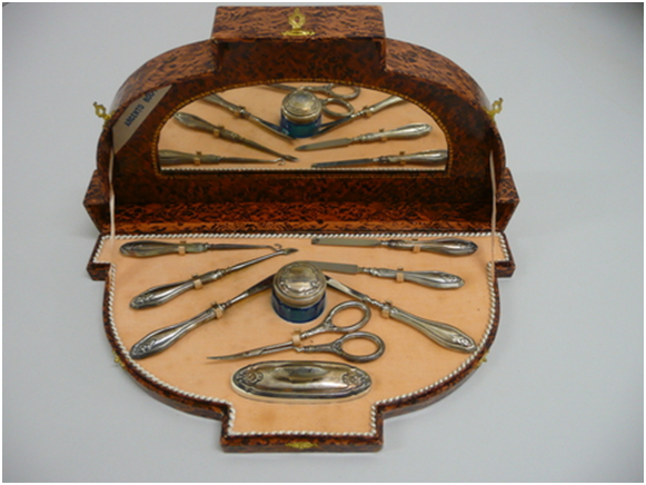 Набор Викторианской эпохи: в деревянном ящичке есть зеркало, крючки для шнуровки одежды, ножницы, пилочки, полисуар и баночка для полировального воска.