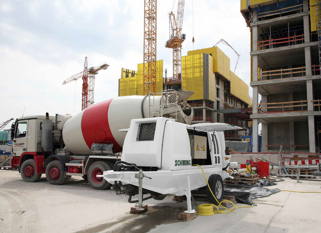 Стационарный бетононасос на строительной площадке в рабочем состоянии.