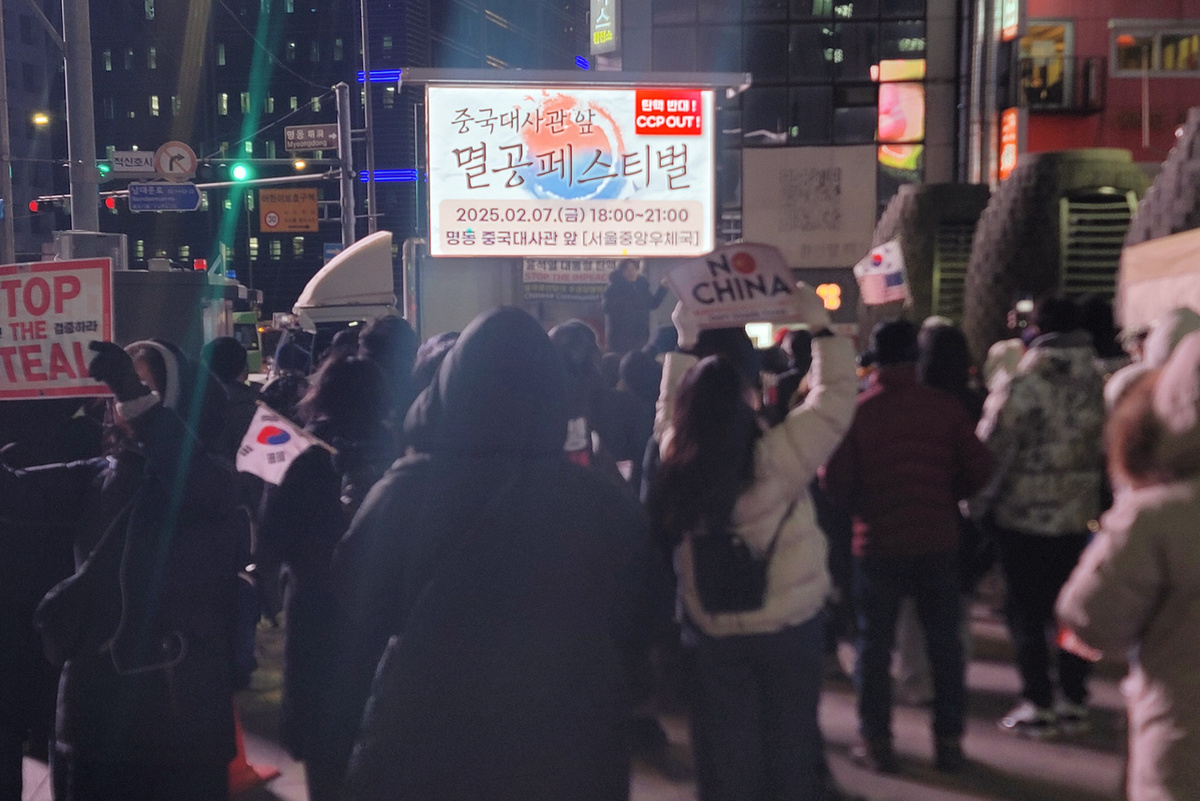 Люди собираются на митинг против Коммунистической партии Китая у китайского посольства в Сеуле в пятницу вечером (Ренхап)