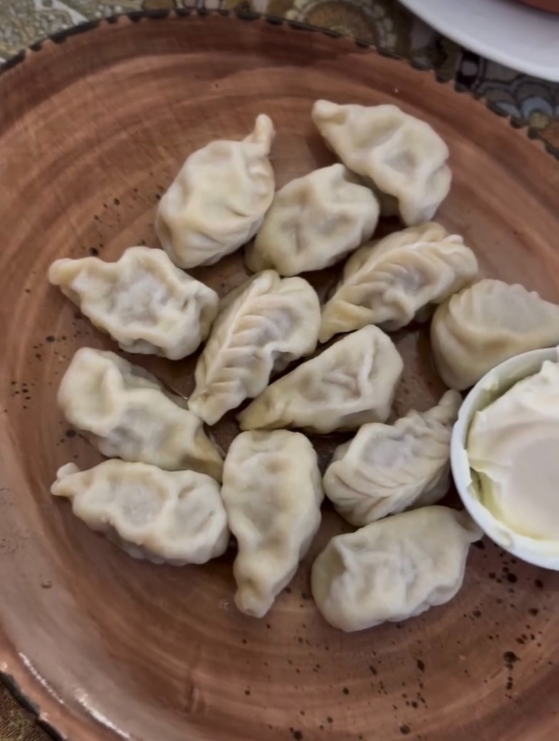 
Напрягайте свои вкусовые рецепторы, поговорим о вкусном! Не устану повторять, что Калмыкия уникальный , аутентичный регион, который уже много веков хранит свою культуру!
Национальная кухня здесь, это не развлечение для туристов, ее готовят в каждом доме и уж , тем более, какая встреча без калмыцкого чая!
Калмыцкий чай совершенно не похож на , так скажем, привычный нам чай. Он терпкий, соленый , разбавленный молоком. По старому рецепту для калмыцкого чая использовали самые грубые части чайного куста, а не только верхние листики, поэтому отвар получался крепким и горьковатым. Туда обязательно добавляли молоко и бараний жир, могли еще кинуть пару лавровых листьев. Вроде и чай , а вроде и бульон или вообще странное зелье! Но в сложных степных условиях , это было необходимо для выживания. Сахар и сладости вызывали жажду, а вода была в дефиците, поэтому соль нужна была для задержки в организме воды. А бараний жир и вовсе являлся лекарством от всех болезней! На барашках вся степь держится! И их же употребляют в каждом национальном блюде!
На фото вы можете увидеть суп-махан , с большим куском баранины и картофелем. Так же, местные пельмешки - бёреги , которые начиняют бараниной или говядиной и обязательно добавляют в фарш лук, для сочности! А еще тут с удовольствием едят бараньи потрошки -это блюдо называют «дотур», если вы смелый человек, обязательно попробуйте!
А на десерт, так скажем, выпекают борциг/борцоги -пресные пирожки без начинки , напоминающие хворост .
И это я вам еще про верблюжатину не рассказала!
Да-да , и такое тут едят! Так как верблюды тоже неотъемлемая часть Калмыкии !
Калмыцкая кухня отражает быт кочевого народа — простая, сытная и на скорую руку. Едят то, что быстро готовится и всегда в доступе. Баранина и молоко — две главные составляющие рациона жителя степи.