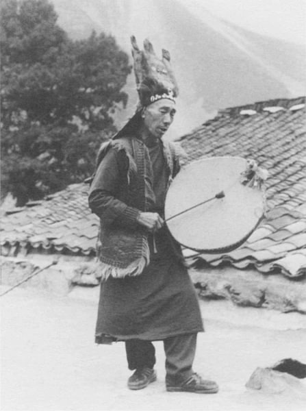 Шаман в ритуальной шапке и с бубном из овечьей шкуры