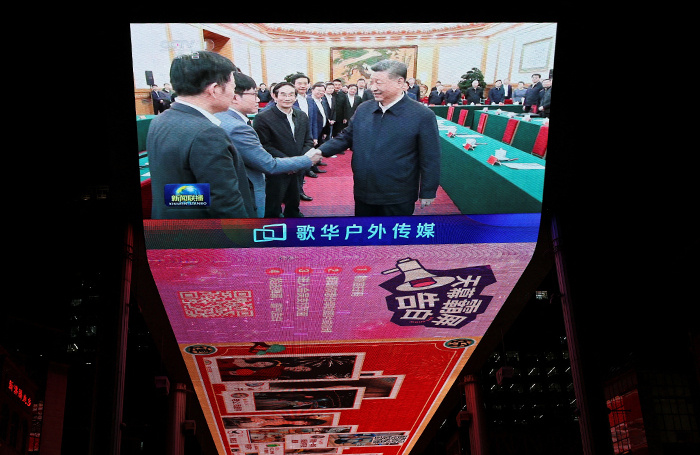    На экране показываются новостные кадры встречи председателя КНР Си Цзиньпина с руководителями бизнеса в Пекине.Florence Lo/Reuters