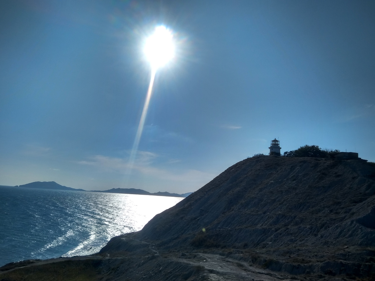 Маяк Ильинский на фоне прибрежного морского пейзажа