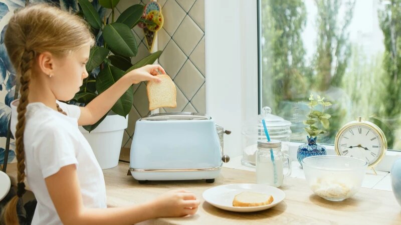     Девочка кладёт хлеб в тостер. Фото: ru.freepik.com, автор master1305.