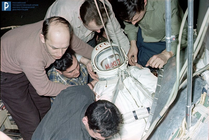 Укладка манекена в скафандре «Беркут» в кабину корабля 3КД «Космос-57». 1965 г. РГАНТД. Арх. № 0-360 цв.