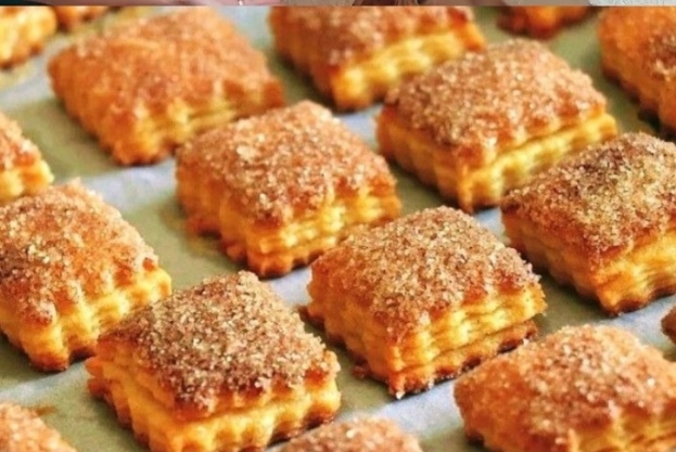 Приготовление слоеного печенья:В небольшую чашу разбиваем яйцо, высыпаем сахар и соль, вливаем кефир и тщательно перемешиваем. В отдельной миске смешиваем муку и разрыхлитель.Холодное сливочное масло разрезаем на небольшие кусочки и кладем в муку. Руками перемалываем масло в муке до состояния крошки. В крошку вливаем смесь из кефира, быстро замешиваем тесто.Полученное тесто накрываем тарелкой и убираем в холодильник на полчаса. Соединяем сахар и кокосовую стружкуКолобок теста скалкой раскатываем в прямоугольный тонкий пласт. Посыпаем пласт смесью сахара и кокосовой стружки, слегка вдавливаем в тесто скалкой.Два противоположных края пласта сворачиваем внутрь. Посыпаем тесто снова сахаром и стружкой, слегка придавливаем.Получается более тонкий прямоугольник. Концы этого прямоугольника снова складываем внутрь, опять посыпаем начинкой.Прикладываем край тонкого прямоугольника ко второму краю, посыпаем тесто начинкой.Получается подобие колбаски, ее раскатываем в более тонкую пластину.Посыпаем пластину теста сахаром и стружкой, делим поперек на небольшие прямоугольники.Выкладываем будущее печенье на противень, застеленный пергаментом. Выпекаем печенье в духовке при 180 градусах 15 минут