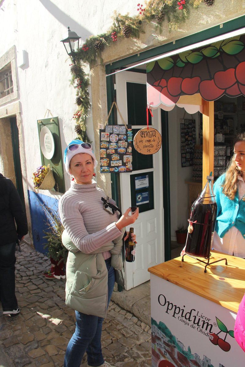 пью местный виншневый ликер Джинджу за 1 евро из шоколадной рюмки