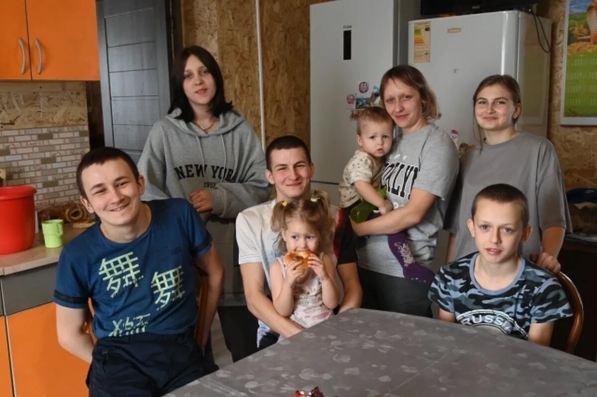    Сложно застать семью в полном составе. На фото трое отсутствуют, в школе на занятиях. Глава семье в центре с дочерьею на коленях.