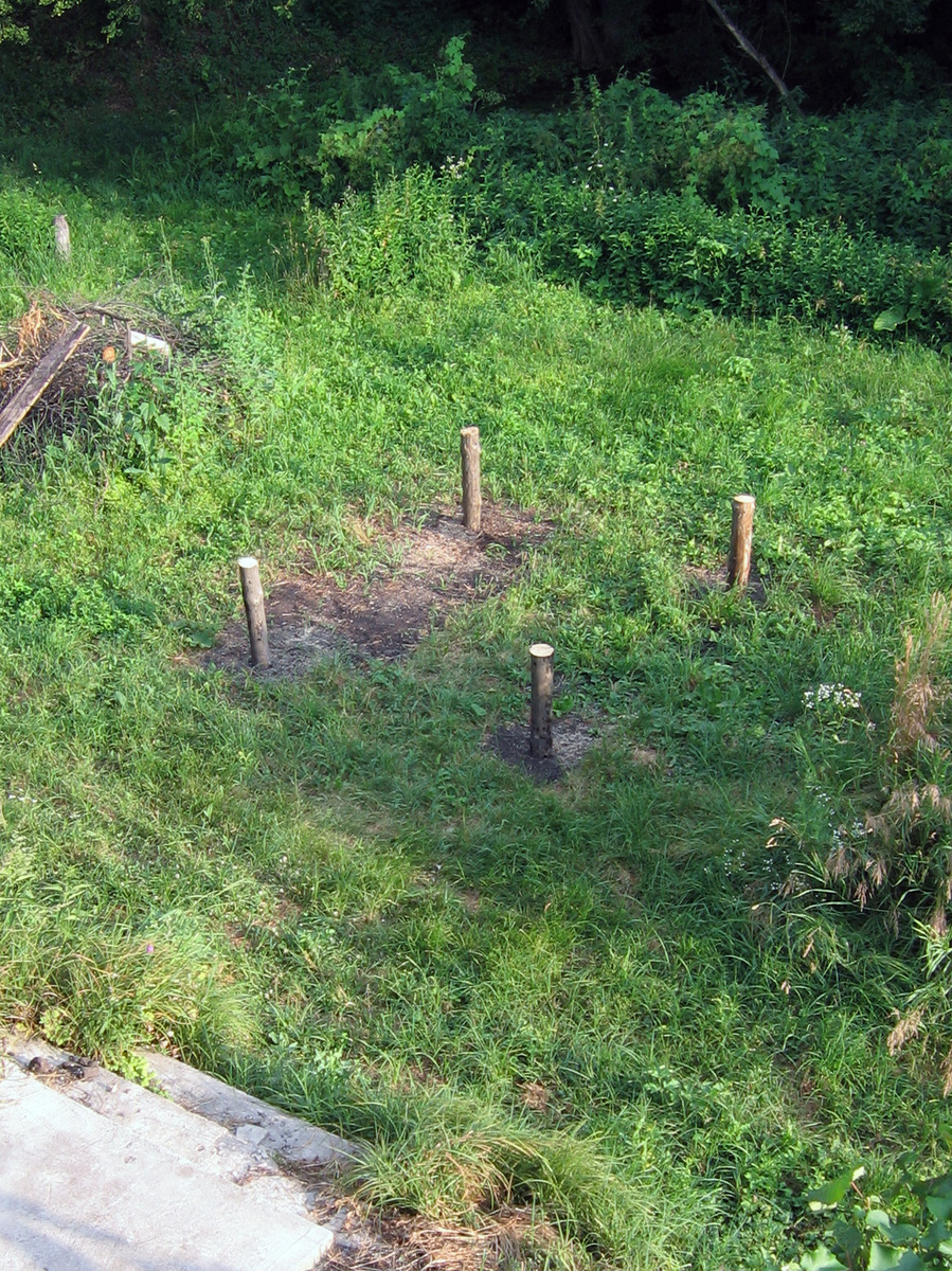 Вбиты и обрезаны по уровню столбы, в осях фигурных колонн флюгерной