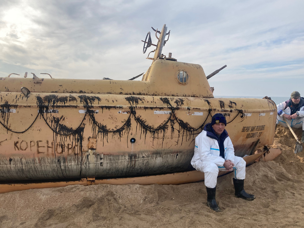 Неизвестный мужчина у подводной лодки испачканной в мазуте 