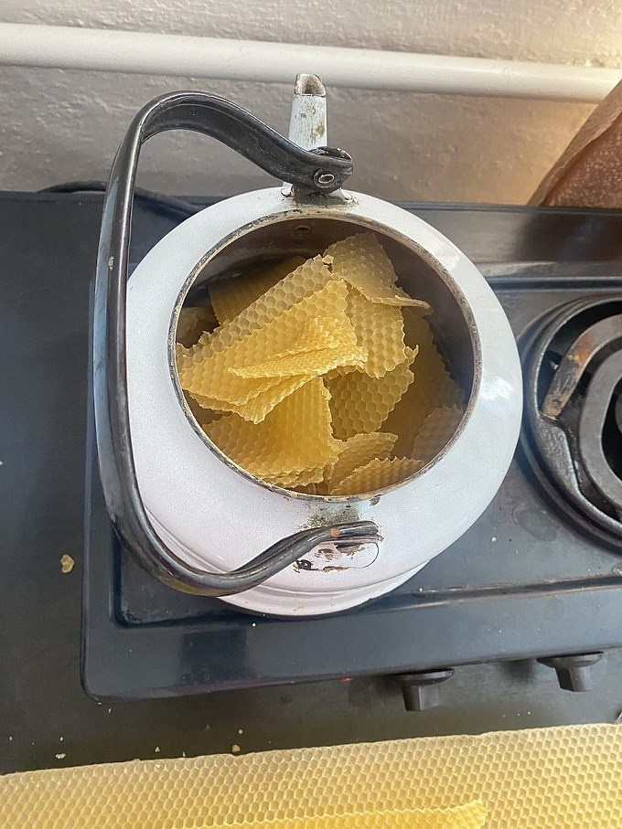 Наломаный воск в чайнике на плите