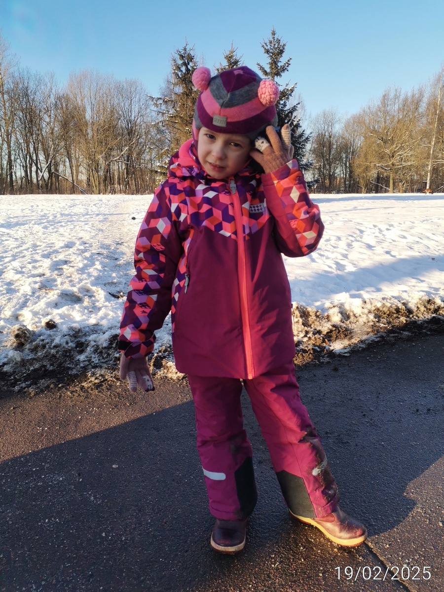 Агния идёт с колонкой у уха. 