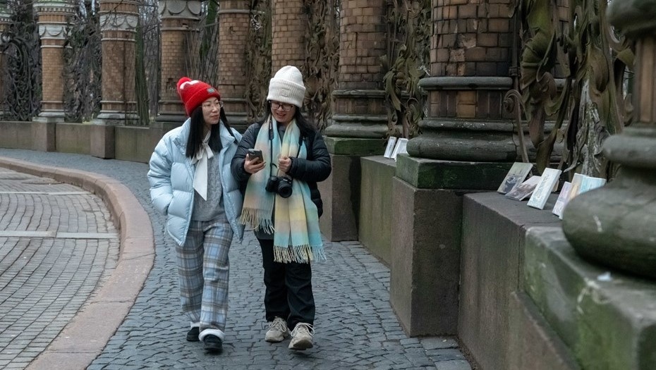    Туристки из Азии прогуливаются вдоль ограды Александровского сада в центре Петербурга. Автор фото: Михаил Тихонов / "Деловой Петербург"