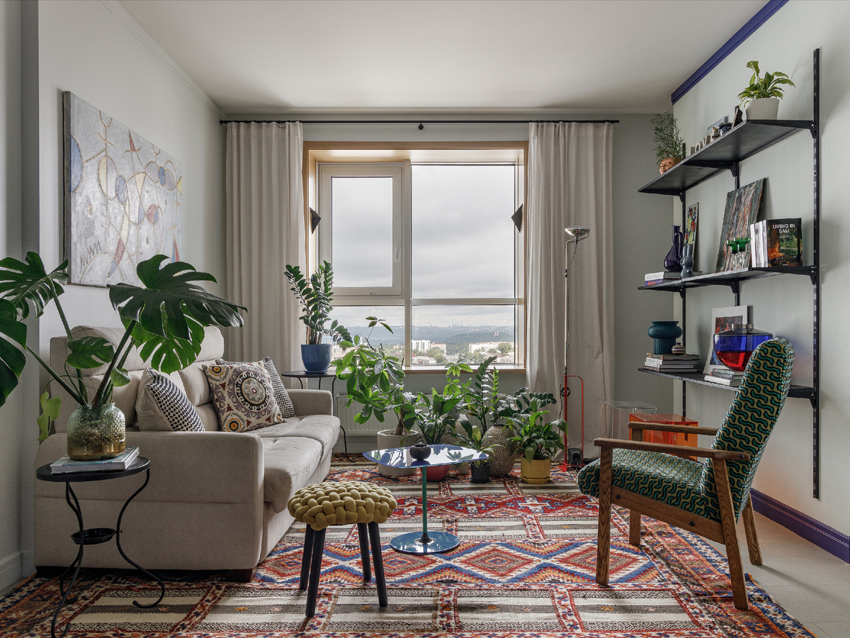 Гостиная. Диван Pohjanmaan, стеллаж куплен в «Леруа Мерлен», столик Kartel, торшер Flos
 винтажное кресло обитянуто тканью Designers Guild, на полу марокканский ковёр ручной работы.