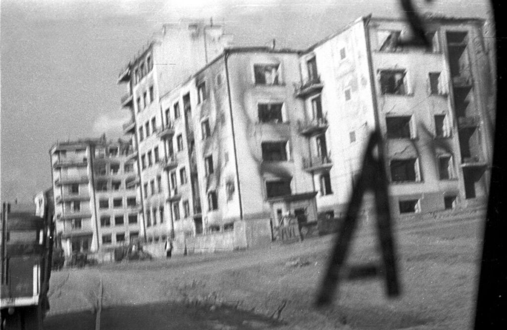 Вид на сильно разрушенный и окончательно снесенный в 1948 году 100-квартирный Дом специалистов из автомобиля оккупантов на ул. Советской (будущая Гауптштрассе) в оккупированном немецкими войсками Минске, июль 1941 г.