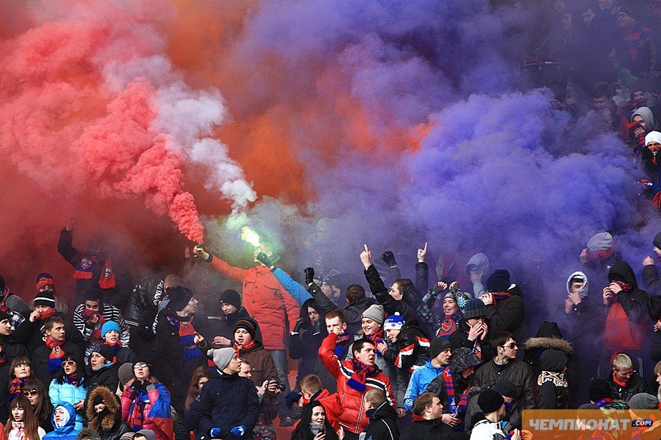 Современный футбольный стадион с цветными дымовыми шашками и флагами