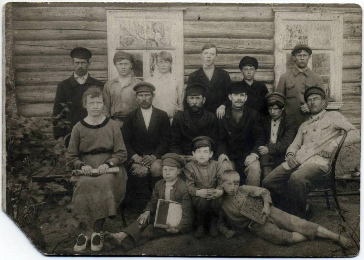 Работники Городищенского волисполкома. На фоне стены бревенчатого деревянного дома с двумя окнами, расположилась группа людей. Впереди на земле сидят трое мальчиков. За ними, на скамье и стульях, сидят пятеро мужчин и одна женщина. В последнем ряду стоят шесть мужчин. В среднем ряду второй справа - поэт Прокофьев Ал. - уполномоченный из Новой Ладоги.