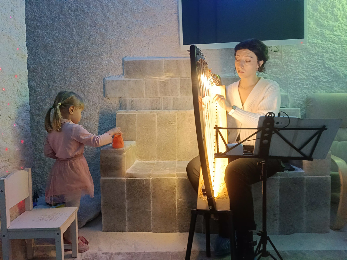 Удачное фото получилось, здесь и арфистка, и общий антураж соляной пещеры, и малышка в кадр забежала