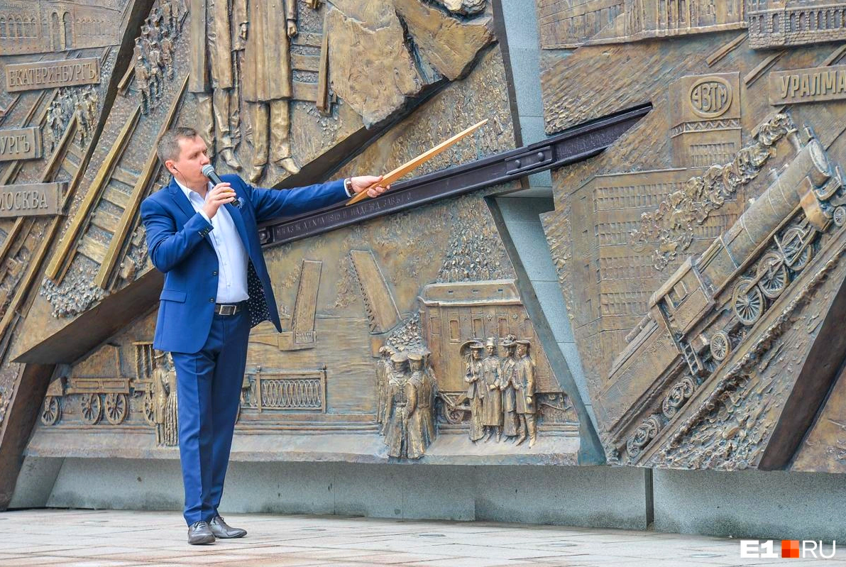 Один из создателей барельефа, художник Сергей Титлинов, рассказывает о изображённых на нём деталях на церемонии открытия 20 июля 2018 года. Фотография с сайта "Екатеринбург Онлайн" (https://www.e1.ru/text/gorod/2018/07/20/65172581)