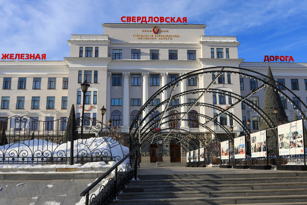 Здание Управления Свердловской железной дороги на улице Челюскинцев. Памятник-барельеф, о котором пойдёт речь, расположен подле него в сквере имени Бабыкина