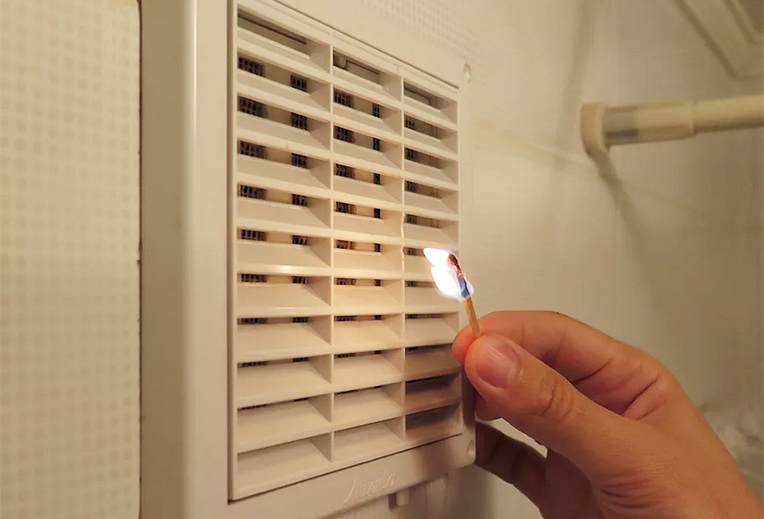 Проверить тягу можно с помощью зажженной спички или листа бумаги, поднесенного к вентиляционной решетке. Если пламя или лист бумаги отклоняется в сторону решетки, значит, тяга есть.