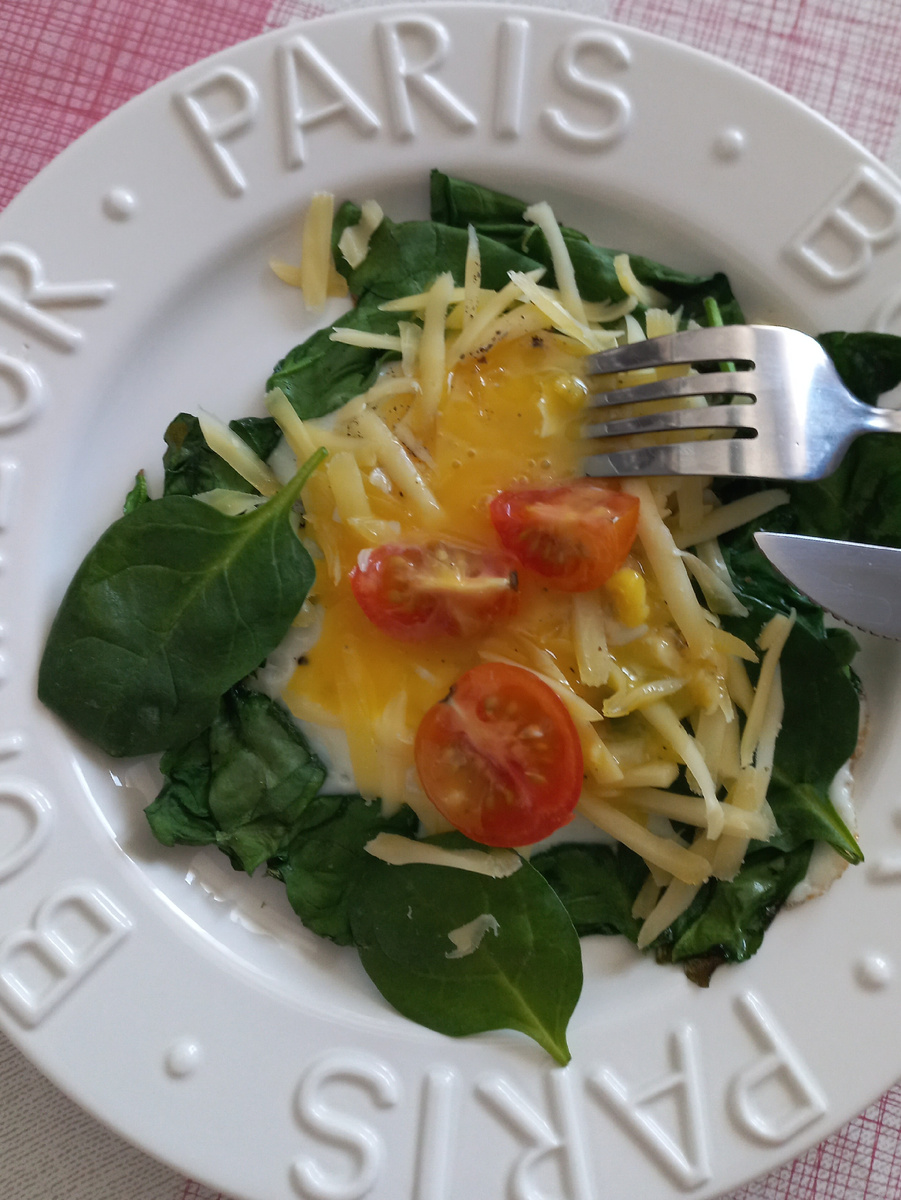 На завтрак была яичница со шпинатом и помидорами . Желток жидкий . Сверху сыр тертый на крупной терке 