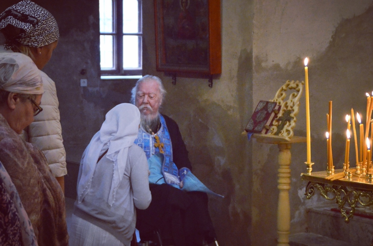 Отец Димитрий (Смирнов) принимает исповедь у прихожан.