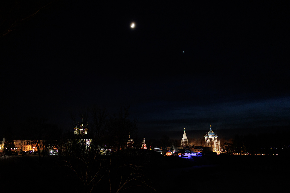 Луна и венера на небе над городом