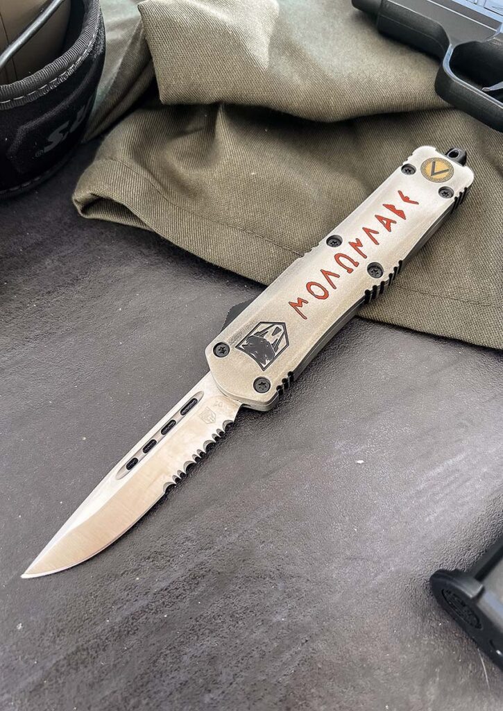 Рукоятка ножа CobraTec OTF имеет покрытие Cerakote® и украшена графикой с надписью «Molon Labe», что в переводе с латинского означает «приди и возьми». Скользящий переключатель с упором для большого пальца обеспечивает быстрое и чёткое выбрасывание и убирание лезвия.