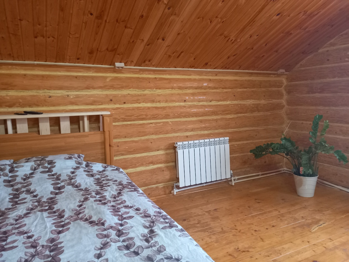 Скошенные потолки вверху и пол из досок нам жить не мешают