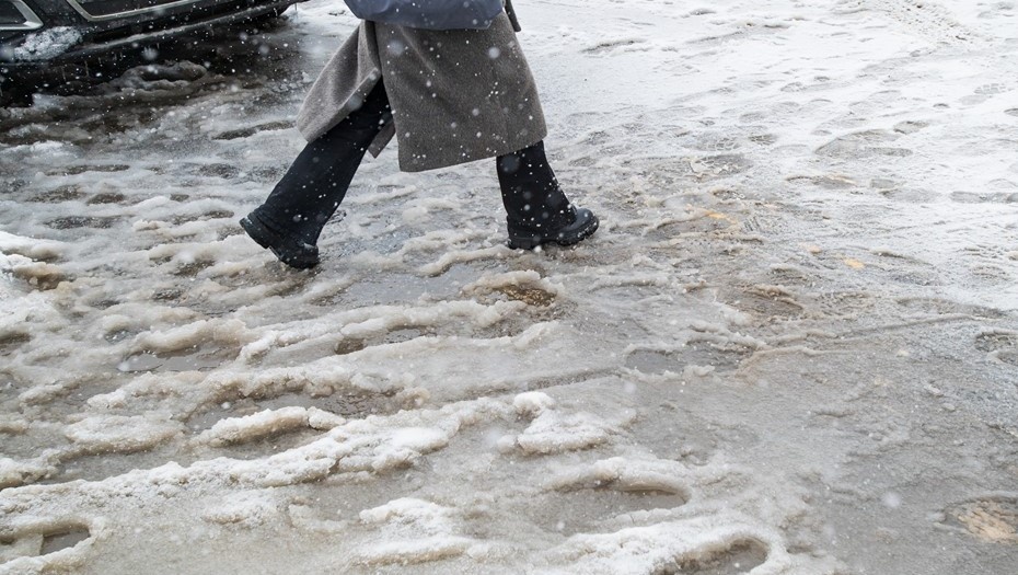    Женщина идёт по улице в Петербурге весной во время дождя и снега. Автор фото: Сергей Ермохин / "Деловой Петербург"