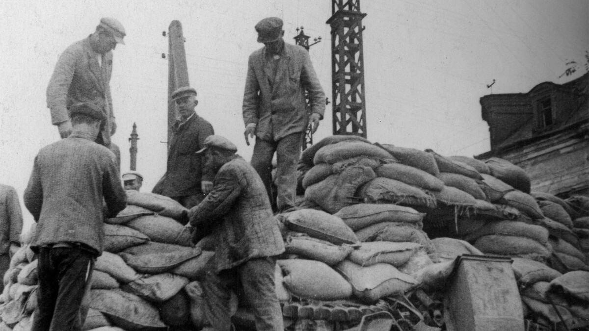 Фото: Яков Халип/Красная звезда/ТАСС (Июль-октябрь 1941 г. Местные жители, строящие баррикады на одной из улиц города в ходе его обороны во время Великой Отечественной войны.)
