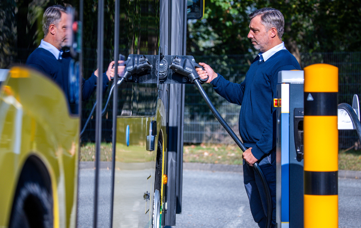 Водитель автобуса вставляет кабель питания для зарядки электробуса в зарядную розетку. Фото: dpa Фото: Jens Büttner/dpa