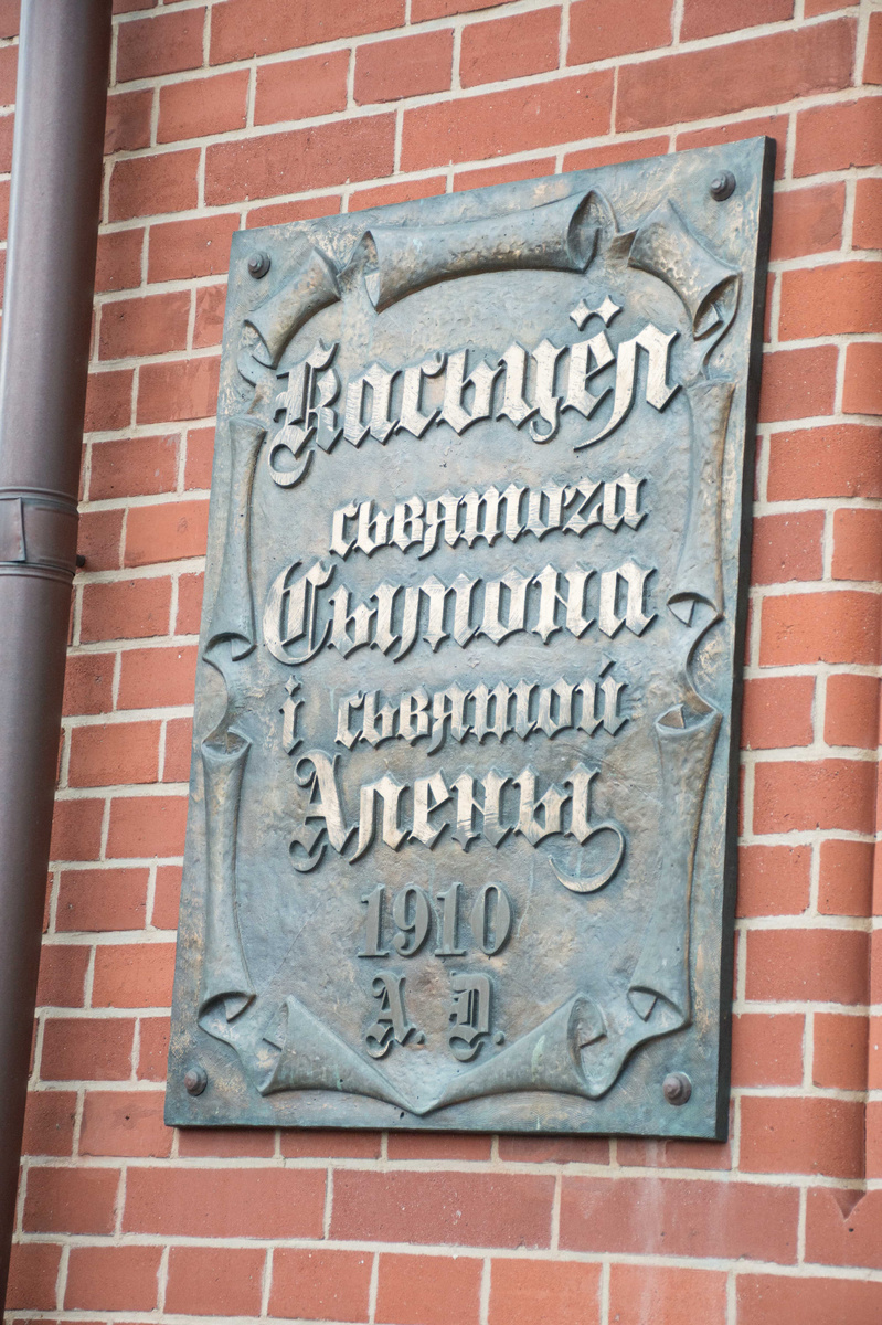 Табличка на стене костела с датой постройки и посвящением