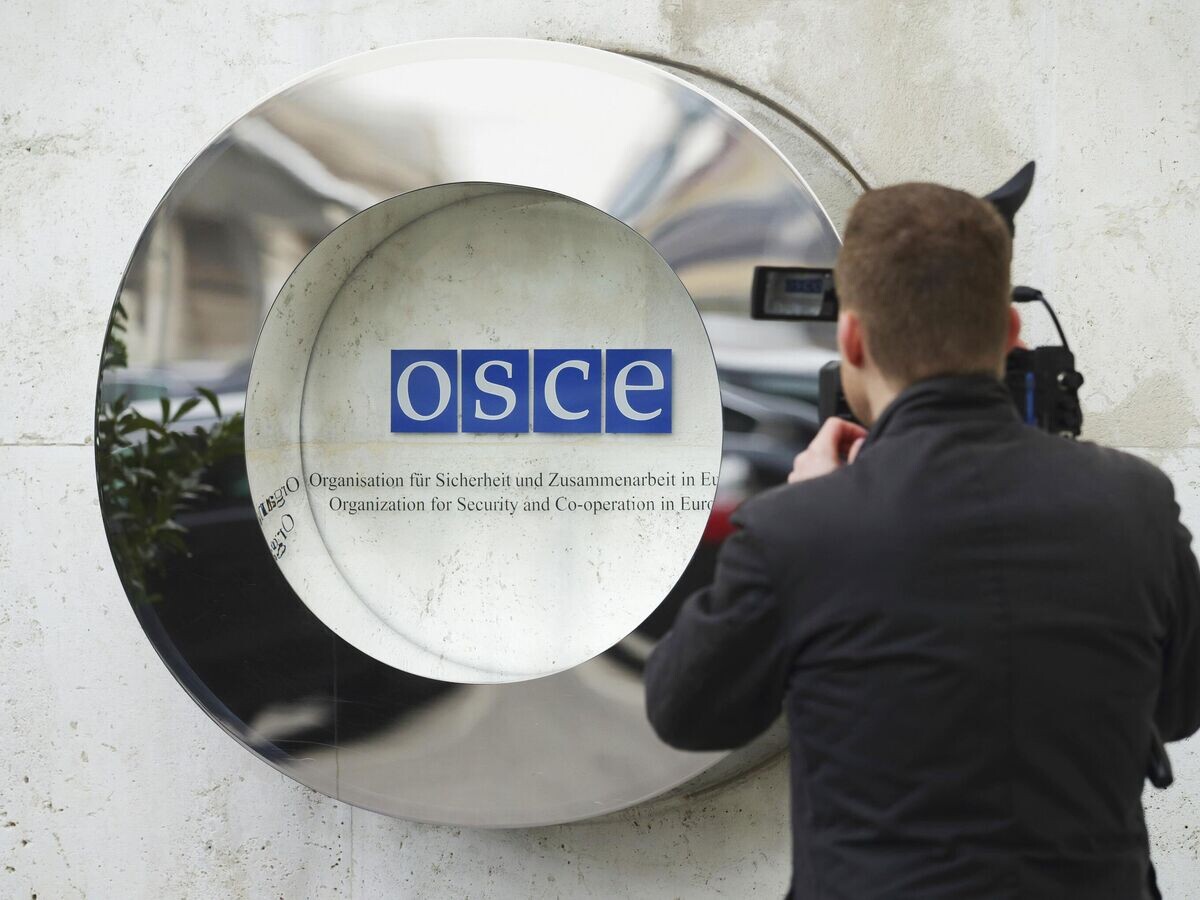    Оператор снимает логотип ОБСЕ© AP Photo / Heinz-Peter Bader