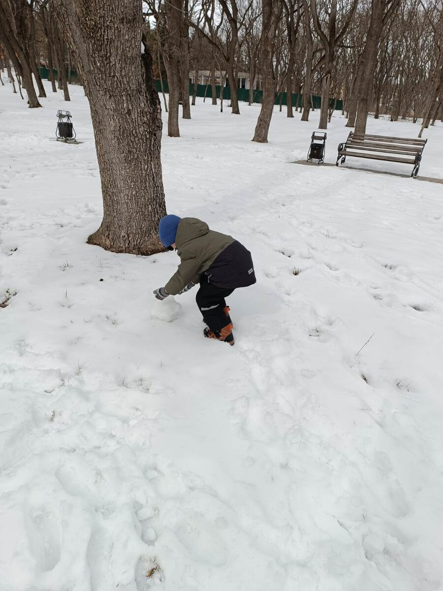 Гуляем в парке с сыном, учиться катать снежки.