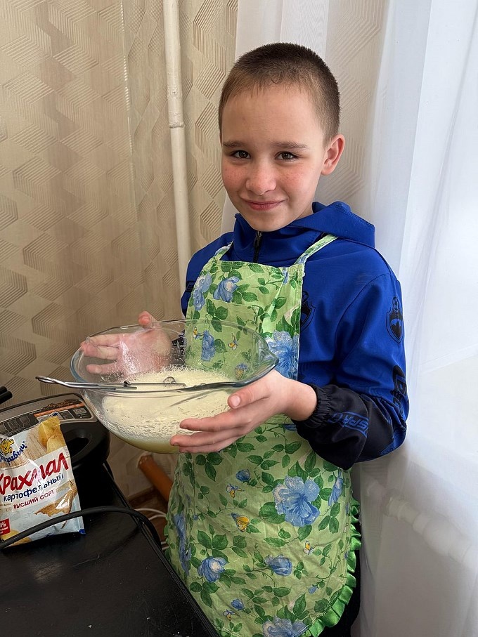 Мальчик держит в руках чашу со взбитыми яйцами