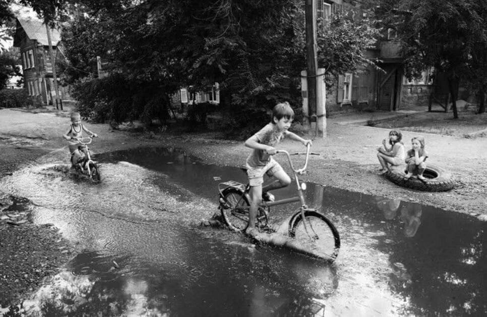 Советский двор. Катание на велосипеде по лужам